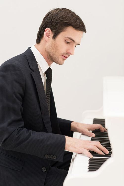 Jeune homme apprenant à jouer du piano