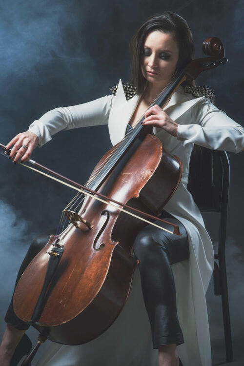 Violoncelliste féminine jouant du violoncelle sur fond sombre