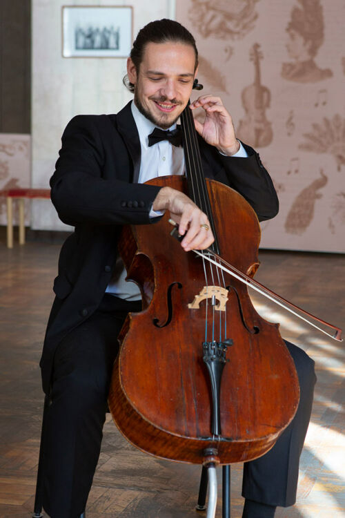 Violoncelliste masculin souriant jouant du violoncelle